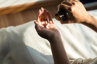 Person holding a bottle of pills over another hand with pills on a textured surface