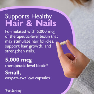 A hand holds a small capsule against a purple promotional graphic that reads 'Supports Healthy Hair & Nails' and mentions 5,000 mcg biotin.